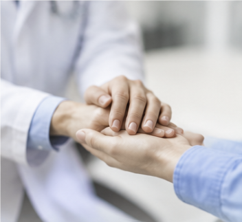 Doctor holding a patient's hand, reassuring them before their procedure